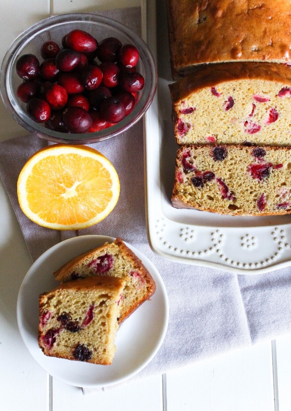 top shot of healthy cranberry bread next to cranberries and an orange