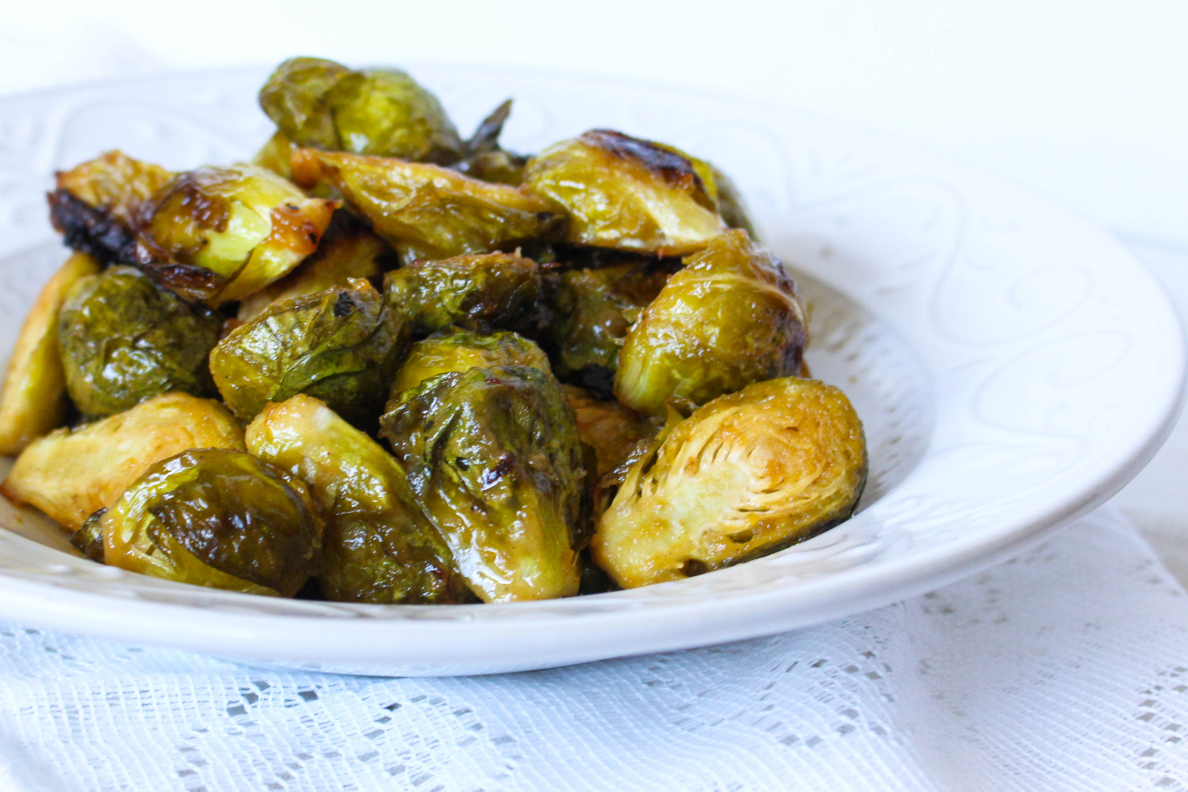 close up of maple mustard glazed brussels sprouts in a white bowl
