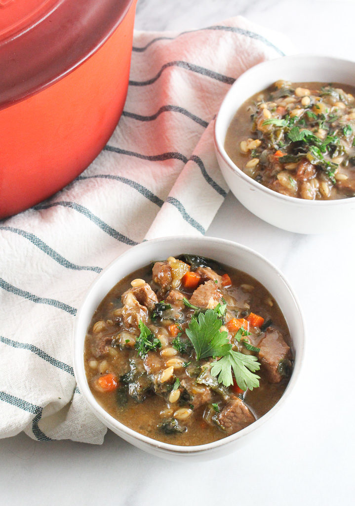 Beef & Barley Soup in bowls with a white and blue striped napkin