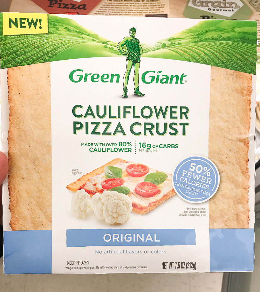 hand holding green giant cauliflower pizza crust