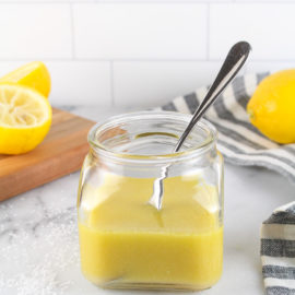 lemon vinaigrette in a small jar with lemons