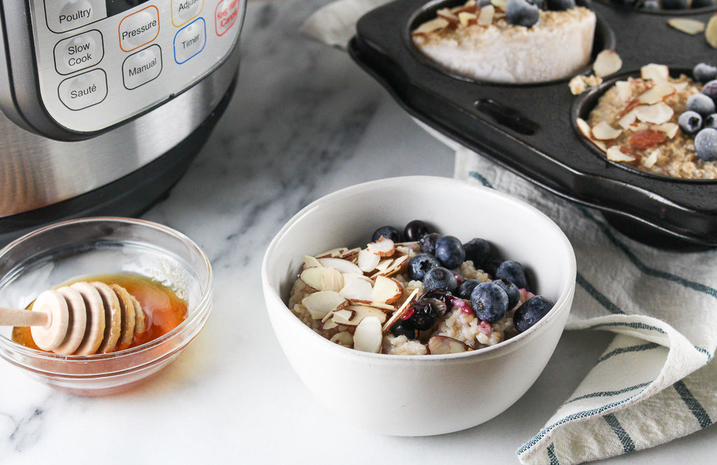 steel cut oats in a small white bowl with blueberries and sliced almonds