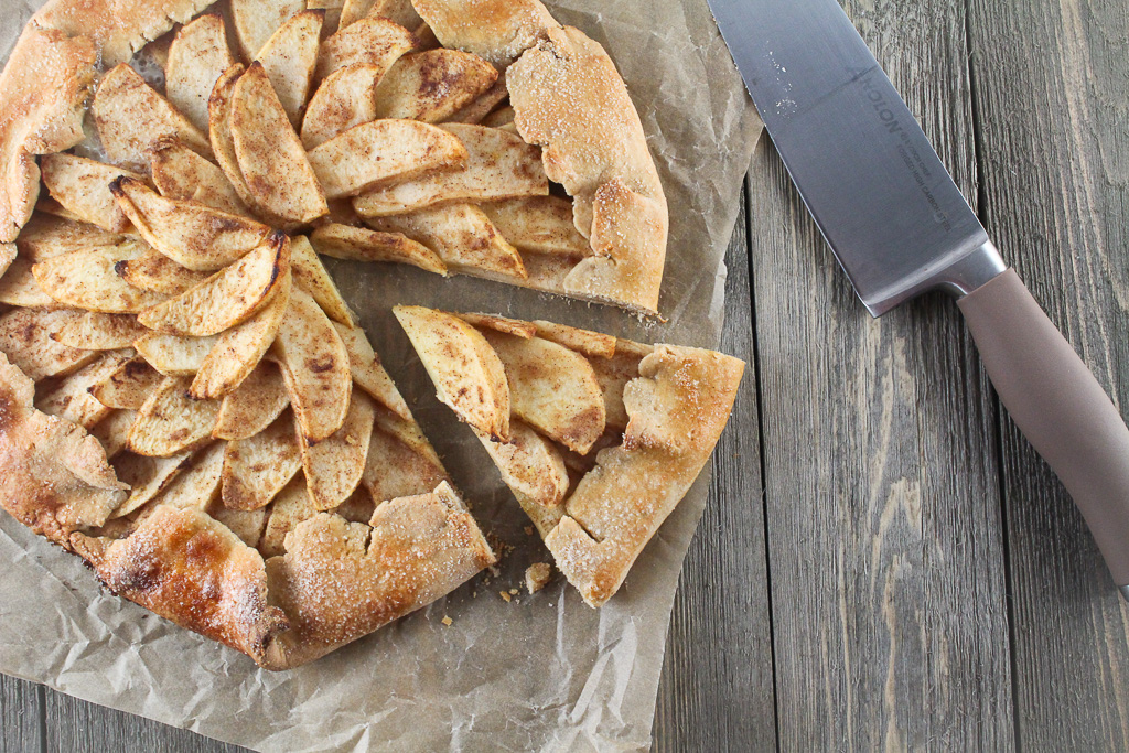 apple galette with a slice removed and a knife